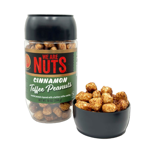 Jar of 'We Are Nuts' Cinnamon Toffee Peanuts with a bowl of peanuts on a white background